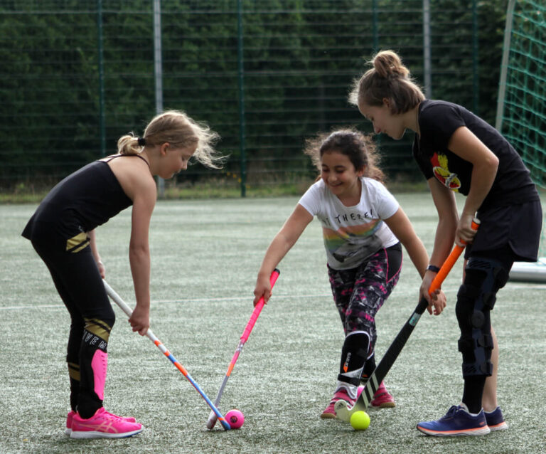 United-Trainerin Jojo Schmitz erklärt zwei Mädchen die Technik im Hockeysport. Foto: Wagner