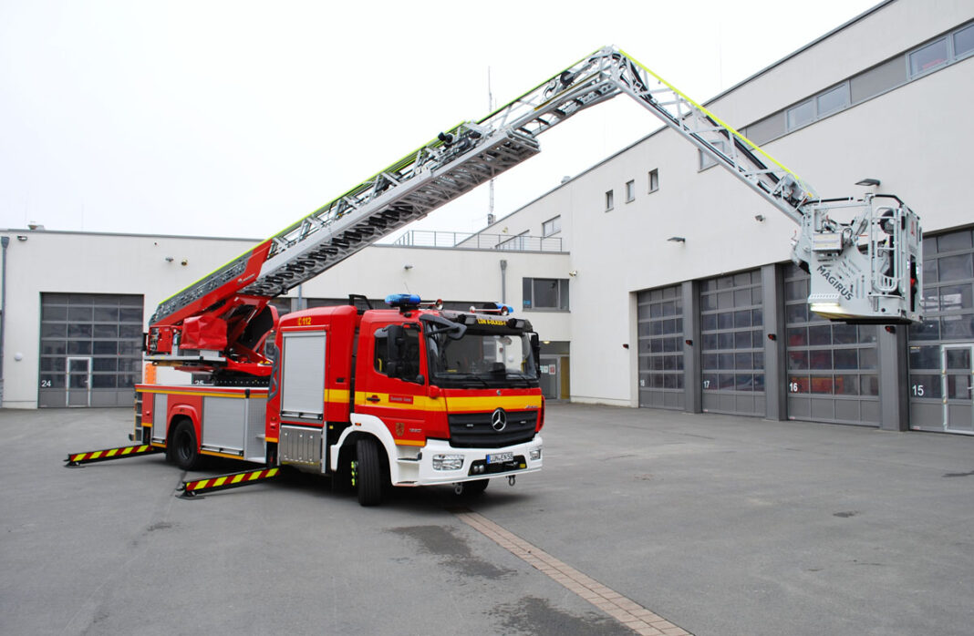 Bild 1 Neue Drehleiter Berufsfeuerwehr von vorne Die neue Drehleiter der Feuerwehr Lünen auf dem Hof der Feuer- und Rettungswache. Sie „hört“ auf den Funkrufnahmen „LÜN-8-DLK23-1“, den sie wie alle Feuerwehrfahrzeuge auf der Windschutzscheibe trägt: Die 8 steht für den Löschzug der Berufsfeuerwehr, „DLK“ für „Drehleiter mit Korb“, die 23 für die Nenn-Rettungshöhe in Metern und mit der letzten Ziffer werden gleichartige Fahrzeuge innerhalb eines Löschzugs durchnummeriert. Foto: Stadt Lünen