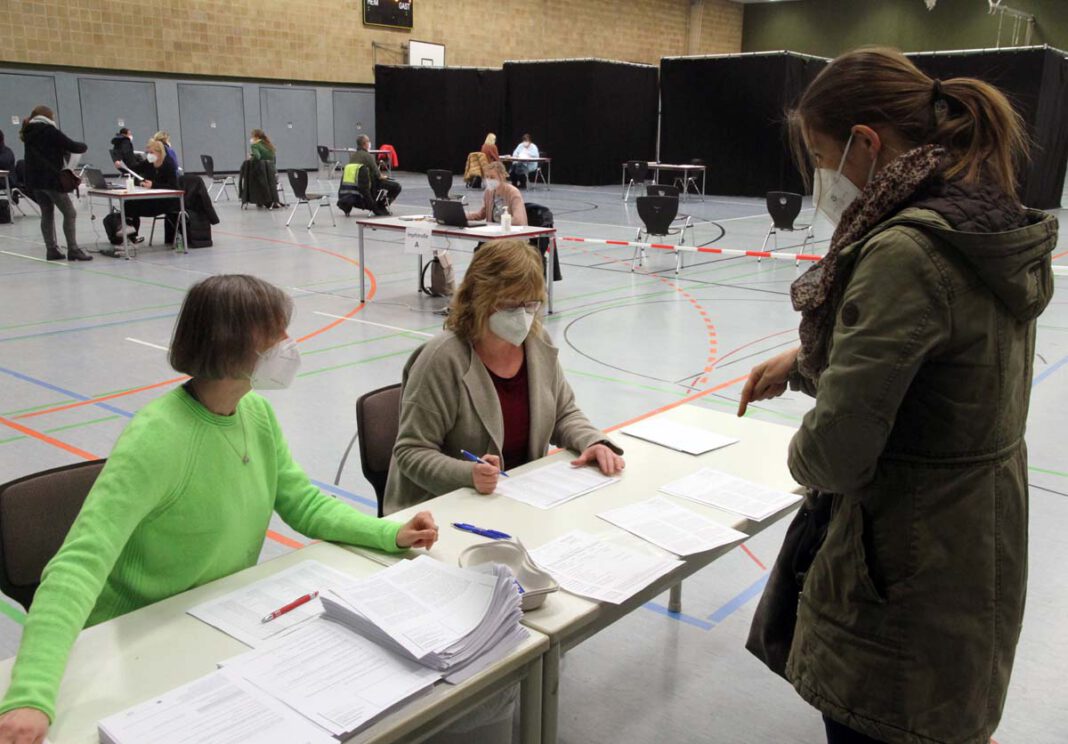 Impfen_Klimek4 Kerstin Obrikat (links) und Claudia Barth empfangen Ina Klimek an der ersten Station und prüfen die Unterlagen. Foto: Wagner