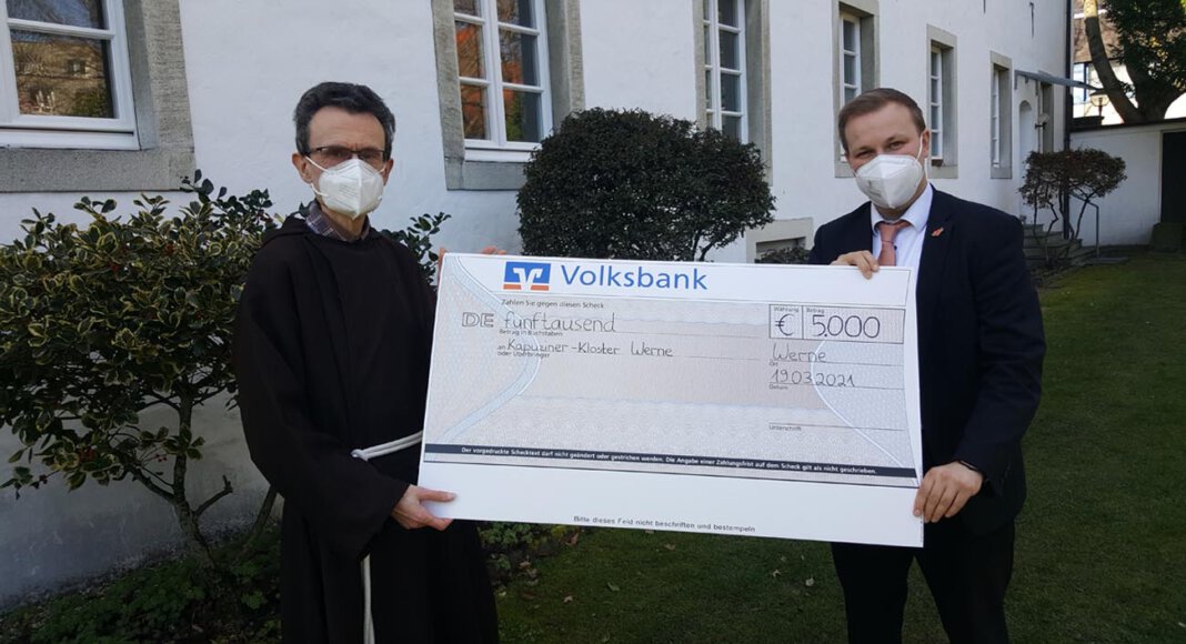 Pater Romuald nahm den Spendenscheck aus den Händen von Volksbank-Sprecher Philipp Gärtner entgegen. Foto: Wagner