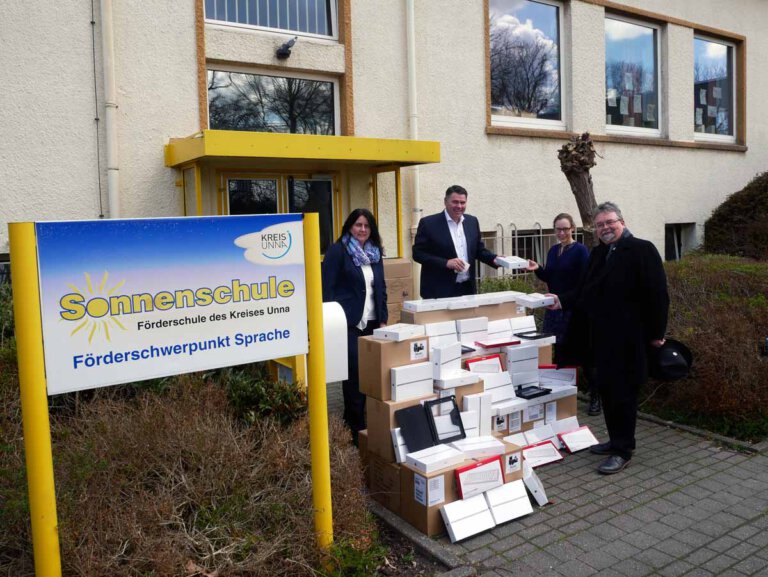 Landrat Mario Löhr und Fachbereichsleiterin Anja Seeber überreichen die digitalen Endgeräte an Susanne Wächter, Leiterin der Sonnenschule und Helmut Gravert, Leiter des Freiherr-vom-Stein-Berufskollegs Werne. Foto: Volker Meier – Kreis Unna.