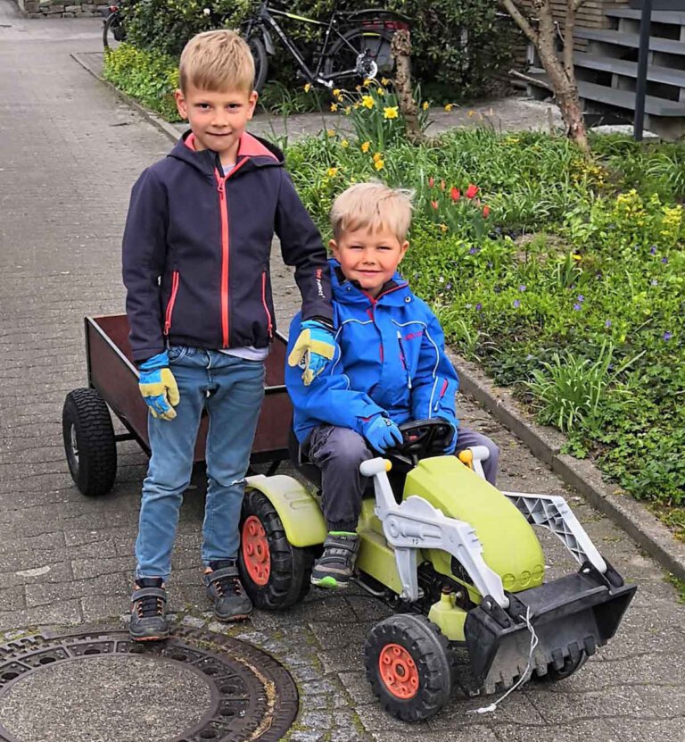 Unterwegs mit Tret-Trecker und Anhänger: Elias Brinker (5) und Enno Hagenkamp (6) reinigen ihr „Revier“ von Müll. Foto: Isabel Schütte