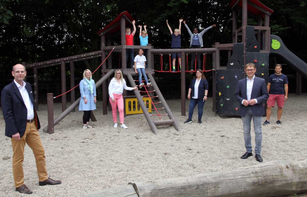 Grundschule Stockum_Schulhof 2 Martin Abdinghoff (links) und Bürgermeister Lothar Christ, beide als Vertreter der Sparkassenstiftung, freuen sich mit Schul- und Elternvertretern sowie Kindern über die vielen Spielgeräte auf dem Hof der Kardinal-von-Galen-Schule. Foto: Wagner