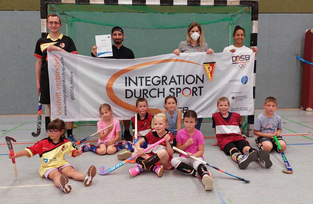 HUW_Stützpunktverein Stefanie Hellmann vom KreisSportBund Unna (hinten, 2. von rechts) überreichte die Urkunde an das Trainerteam und Kinder von Hockey United Werne. Foto: Wagner