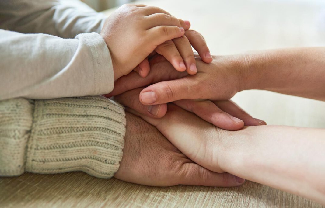 Kind und Senioren stapeln Hände als Spiel „Familienbildung verbindet“ lautet das Motto für das neue Programm der Familienbildungsstätten in Werne und Selm. Foto: FBS