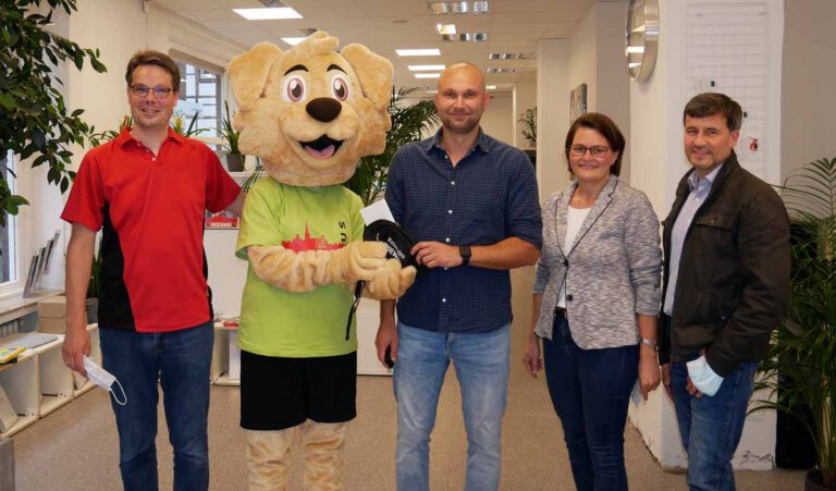 Rafael Smoczynski nahm den Reisegutschein aus den Pfoten von Maskottchen Kira entgegen. Rechts: Dorothee und Frank Wiewel vom gleichnamigen Reisebüro, links: André Wagner (WERNEplus). Für das Foto wurden die Masken kurz abgenommen. Foto: Gaby Brüggemann