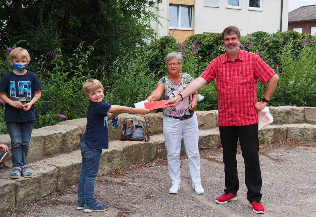 OLYMPUS DIGITAL CAMERA Marita Funhoff und Michael Thews (SPD) förderten das Ferienprogramm an den drei Werner Grundschulen mit einer Spende. Auf dem Foto überraschen sie OGS-Kinder an der Wiehagenschule. Foto: SPD
