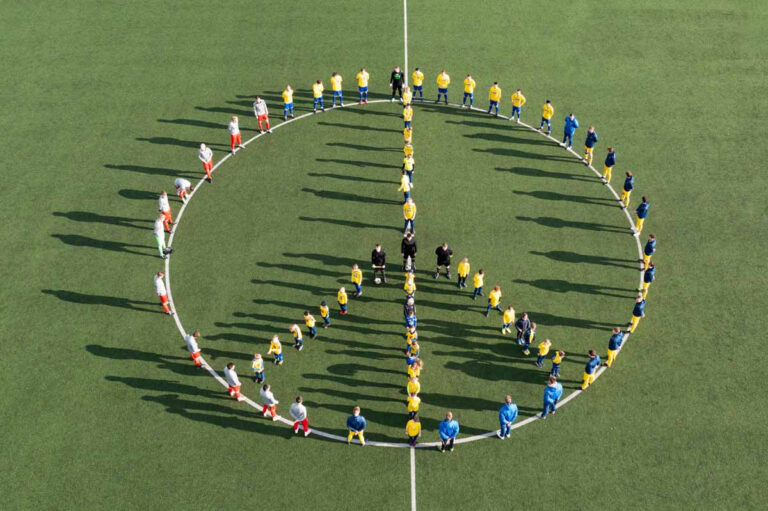 Das Symbol für Frieden stellte der SV Herbern mit seinen Gästen auf dem Sportplatz nach. Foto: Kreativshooting / Isabel Schütte