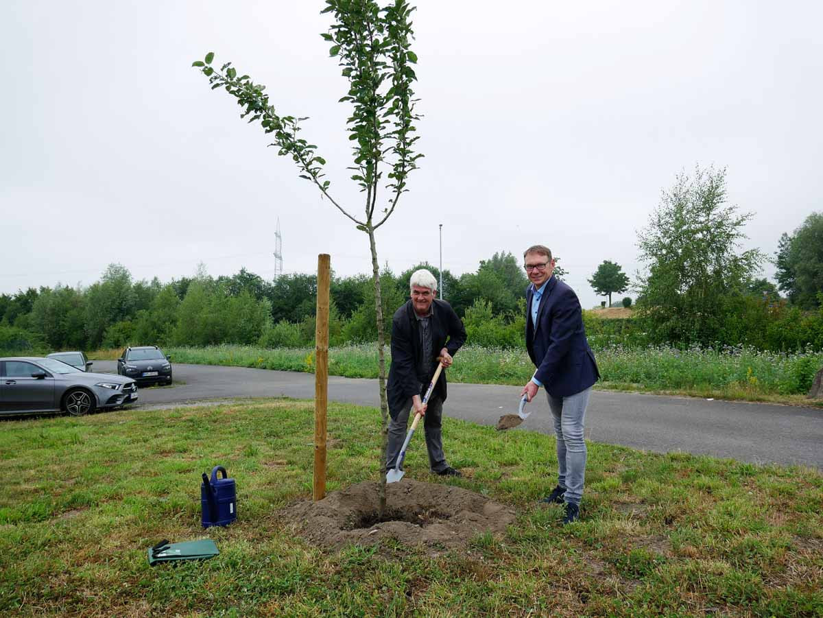 Kurt Becher (links) und Lothar Christ schließen den grünen Gürtel rund um das GARBE-Logistikzentrum mit einem Apfelbaum. Foto: Gaby Brüggemann