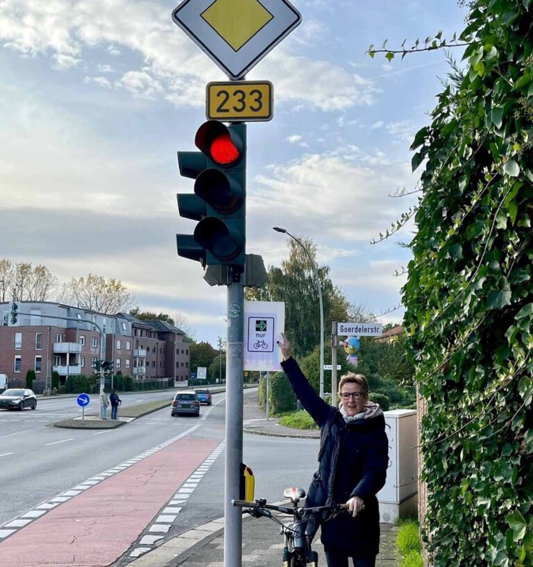 Claudia Lange, Vorsitzende der FDP-Fraktion im Stadtrat, macht anschaulich, um was es geht: ein grüner Pfeil für Radfahrende. Foto: Berthold Lange