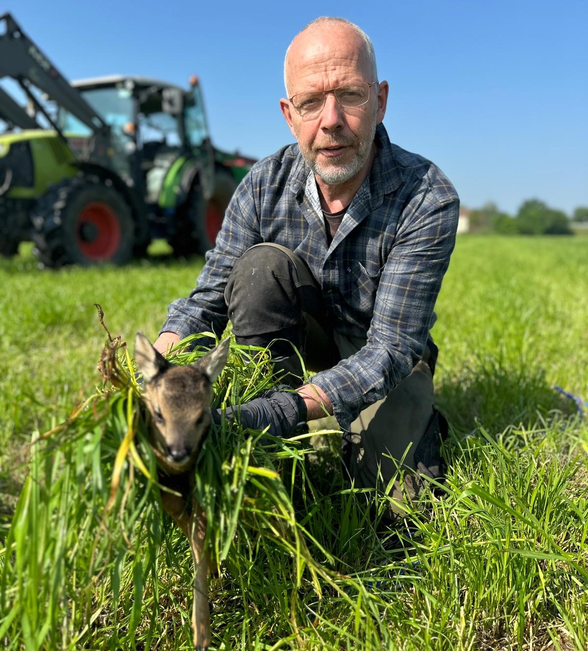 Landwirt Görtz aus Lünen sicherte das Rehkitz nach der Drohnensuche fachgerecht mit viel Gras. Fotos: Möller/Copter-Watch