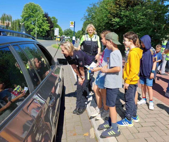 Gemeinsam mit den Polizeibeamtinnen Petra Hölscher und Britta Vormbaum verteilten Kinder der Wiehagenschule "Strafzettel" an zu schnell fahrende Fahrzeugführer. Fotos: Wagner