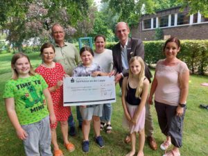 Die Verantwortlichen von Stadt und Caritas freuen sich über die große Spende der Sparkassenstiftung, die Martin Abdinghoff während des Ferienprogramms überreichte. Foto: Wagner