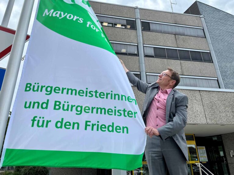 Bürgermeister Christ mit der Mayors-for-Peace-Flagge vor dem Werner Stadthaus. Foto: Stadt Werne