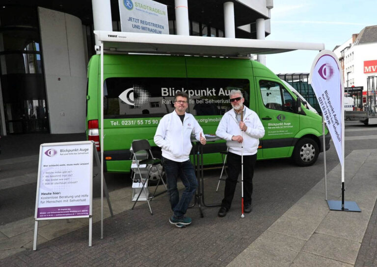 Das Bild zeigt das Beratungsteam mit Uwe Klapp (l.) und Johannes Willenberg vor der mobilen Beratungsstelle. Foto: K. Kribus, Blinden- und Sehbehindertenverein Westfalen e.V.