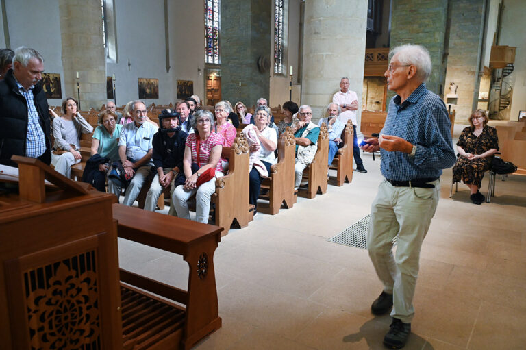 An einem Wandbild in der Christophorus-Kirche erläuterte Karl-Heinz Schwarze, wie man früher mit hilflosen Menschen umging. Foto: MSW