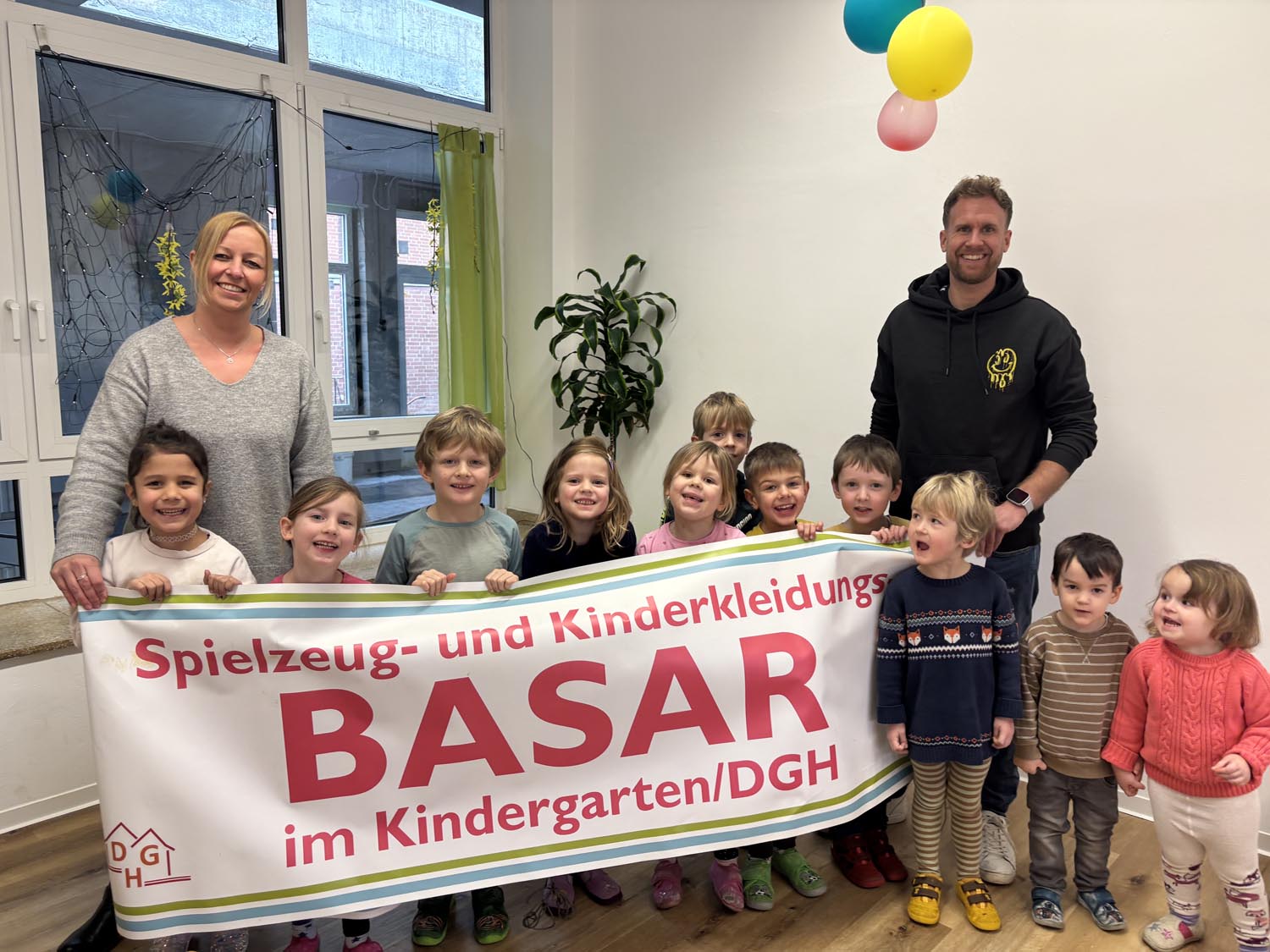 Hoffen auf viele Besucherinnen und Besucher: Jacqueline Schikora vom Basar-Organisations-Team, Kita-Leiter Tim Köhler sowie die Jungen und Mädchen, die die Einrichtung im Herzen von Horst besuchen. Foto: Heinze