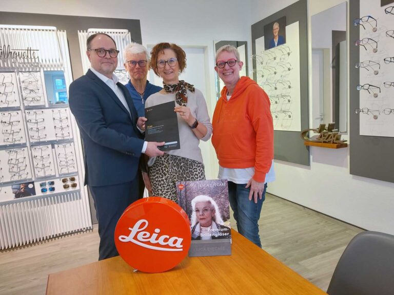 Birgit Havers (Die Brille Werne) und Jörg Oppermann (Leica) bei der Preisübergabe an Karin und Klaus Reher (mitte). Foto: Wagner